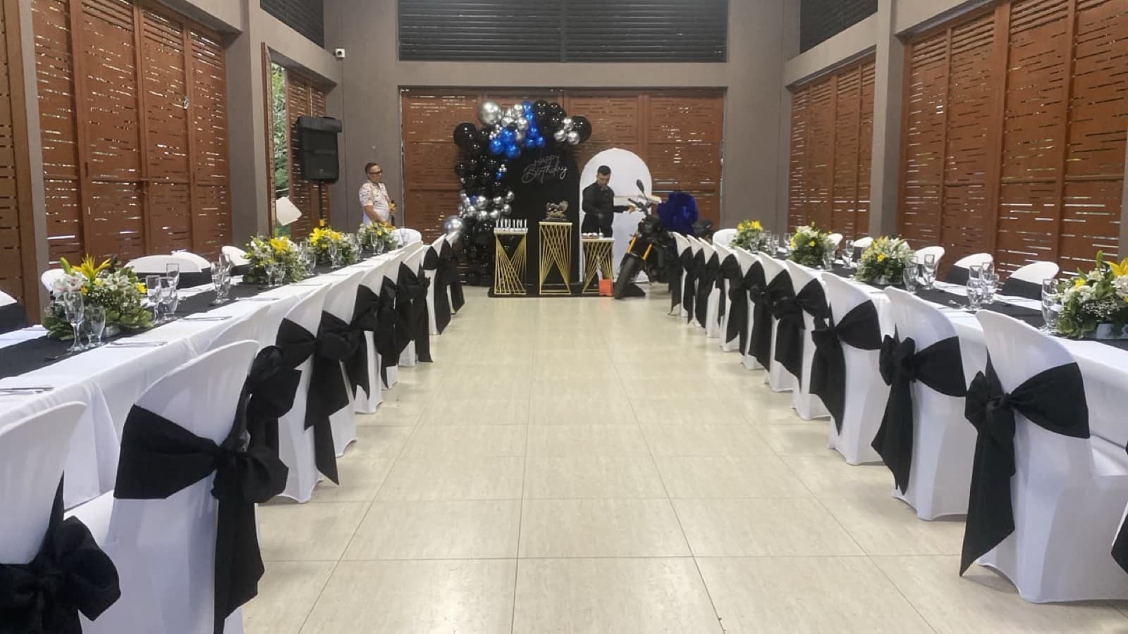 Montaje de banquete elegante en blanco y negro con centros florales en Ibagué, producción de Aura Sabor