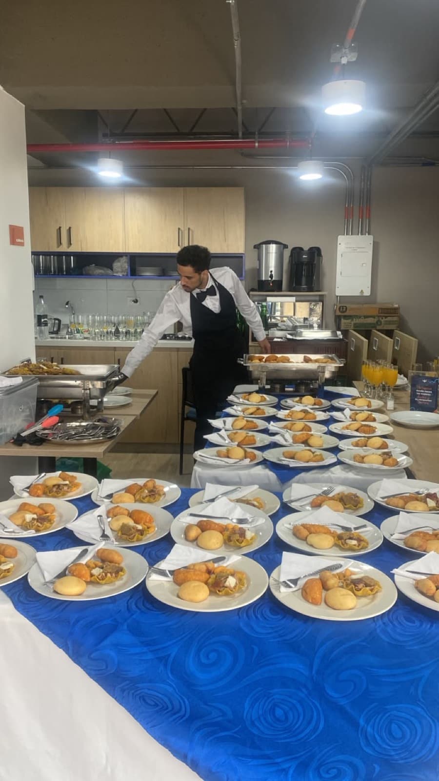Mesero uniformado sirviendo el refrigerio corporativo en la oficina, Aura Sabor Ibagué